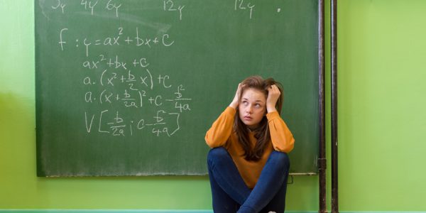 Teenager girl in math class overwhelmed by the math formula. Pressure, Education, Success concept.